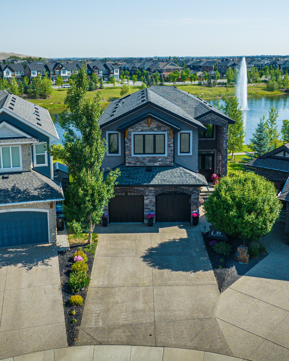 Aerial front elevation of a lakefront home in a Calgary community