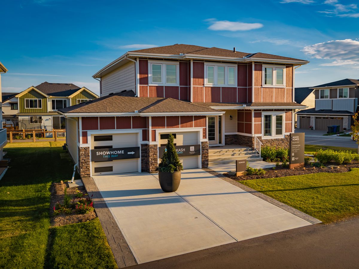 Aerial view of a show home in a new Calgary community at golden hour