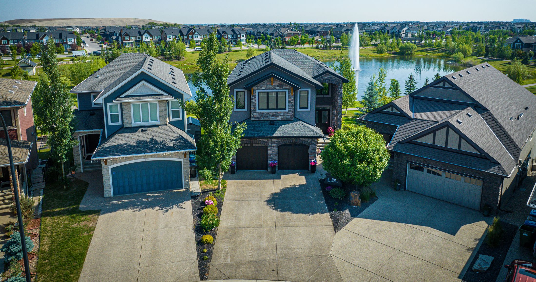 Aerial front elevation of a lakefront home in a Calgary community